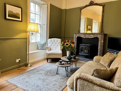 a living room with a couch and a mirror at 5 Castle Hill in Lancaster
