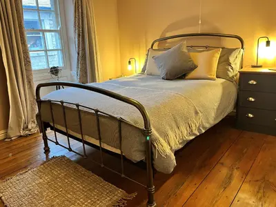 a bedroom with a bed with a metal frame and pillows at 5 Castle Hill in Lancaster