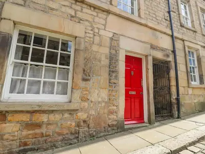 a brick building with a red door and a window at 5 Castle Hill in Lancaster