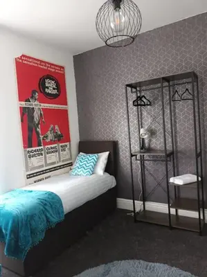a bedroom with a bed and a poster on the wall at Antonio str Liverpool 6 beds in Liverpool