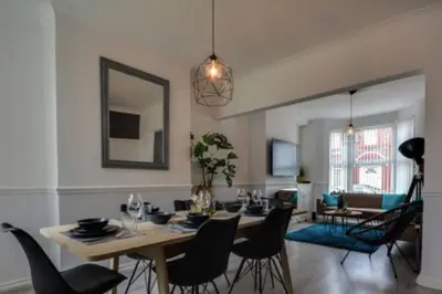 a dining room and living room with a table and chairs at Antonio str Liverpool 6 beds in Liverpool