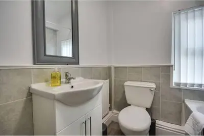 a bathroom with a sink and a toilet and a mirror at Antonio str Liverpool 6 beds in Liverpool