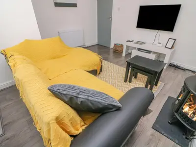a bedroom with a yellow bed and a television at 2 Brook Street in Clitheroe