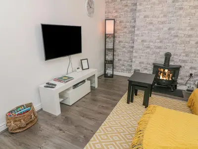 a living room with a television and a fireplace at 2 Brook Street in Clitheroe