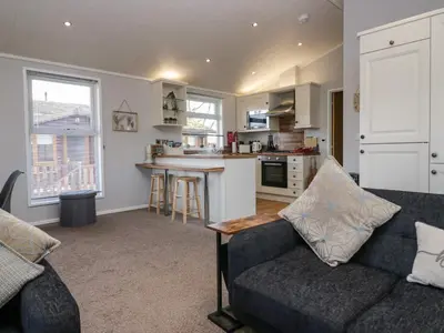 a living room with a couch and a kitchen at Lakeside 20 in Carnforth