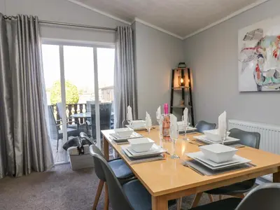 a dining room with a wooden table and chairs at Lakeside 20 in Carnforth