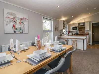 a kitchen and dining room with a wooden table and chairs at Lakeside 20 in Carnforth