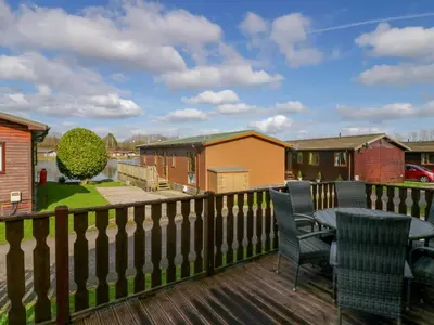 a patio with a table and chairs on a deck at Lakeside 20 in Carnforth