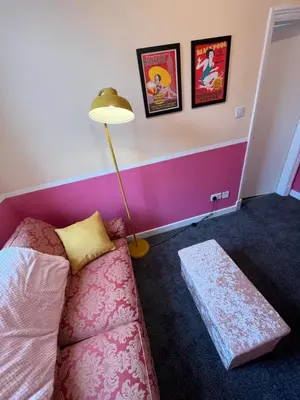 a living room with a pink couch and a lamp at Blackpool Rocks Pleasure Beach in Blackpool