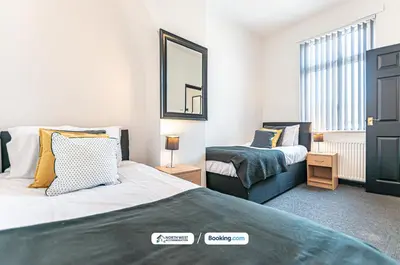 a bedroom with two beds and a mirror at Fully Furnished 3 Bedroom House in Preston with Free Parking in Preston