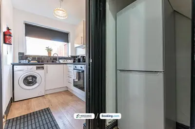 a kitchen with a refrigerator and a washing machine at Fully Furnished 3 Bedroom House in Preston with Free Parking in Preston