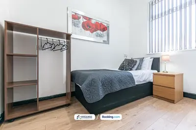 a bedroom with a bed and a book shelf at Fully Furnished 3 Bedroom House in Preston with Free Parking in Preston