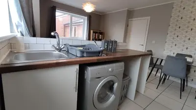 a kitchen with a sink and a washing machine at Modern 1-Bed Flat in Wigan in Wigan