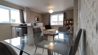 a dining room with a glass table and chairs at Modern 1-Bed Flat in Wigan in Wigan