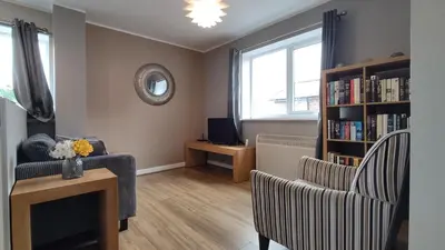 a living room with a couch and a book shelf at Modern 1-Bed Flat in Wigan in Wigan
