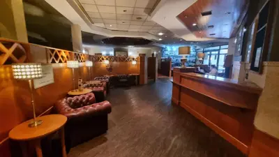 a waiting room with leather chairs and a bar at Wigan Oak Hotel in Wigan