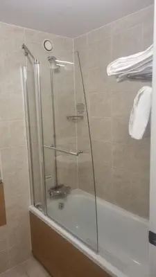 a shower with a glass door in a bathroom at Wigan Oak Hotel in Wigan