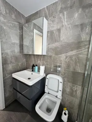 a bathroom with a sink and a toilet and a mirror at Tower Suite Serviced Apartment Blackpool in Blackpool
