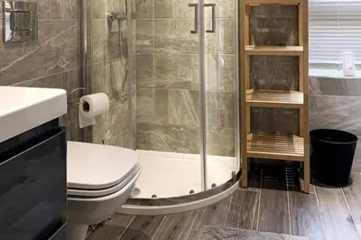 a bathroom with a shower and a toilet and a sink at Tower Suite Serviced Apartment Blackpool in Blackpool