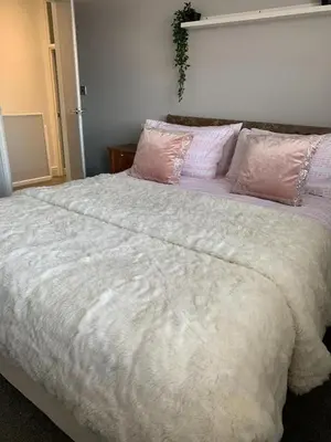 a bedroom with a large white bed with pink pillows at Apartments on Albert Road with free parking in Blackpool