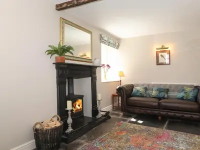 a living room with a couch and a fireplace at Caton Lane House in Grange Over Sands