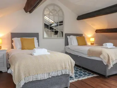 two beds sitting next to each other in a bedroom at Caton Lane House in Grange Over Sands