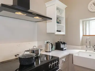 a kitchen with a stove top oven next to a sink at Caton Lane House in Grange Over Sands