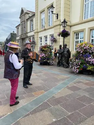 a woman standing next to a man in front of a building at The flat at the crooked house in Ulverston