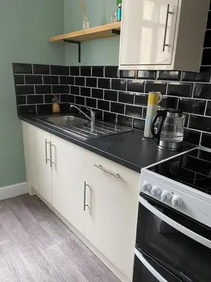 a kitchen with a sink and a stove at The flat at the crooked house in Ulverston
