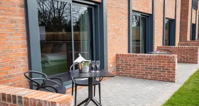 a patio with a table and chairs and a window at Barton Manor Hotel & Spa; BW Signature Collection in Preston