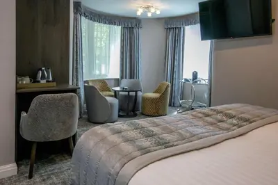 a hotel room with a bed and a desk and chairs at Barton Manor Hotel & Spa; BW Signature Collection in Preston
