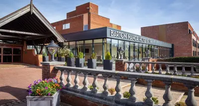 a building with a fence and flowers in front of it at Barton Manor Hotel & Spa; BW Signature Collection in Preston