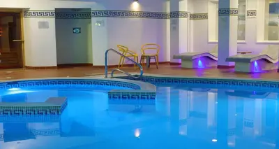 a swimming pool with two chairs and a table at Barton Manor Hotel & Spa; BW Signature Collection in Preston