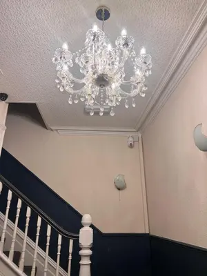 a chandelier hanging from a ceiling next to a staircase at Bronte House - Blackpool in Blackpool