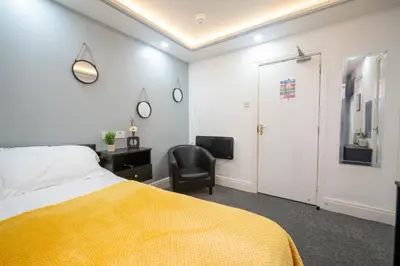 a bedroom with a bed and a desk and a chair at Driftwood Rooms in Blackpool