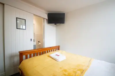 a bedroom with a bed with a television on the wall at Driftwood Rooms in Blackpool