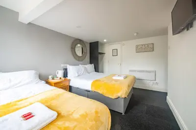 a hotel room with two beds and a mirror at Driftwood Rooms in Blackpool