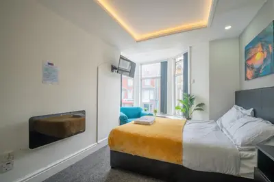 a bedroom with a king sized bed and a tv at Driftwood Rooms in Blackpool