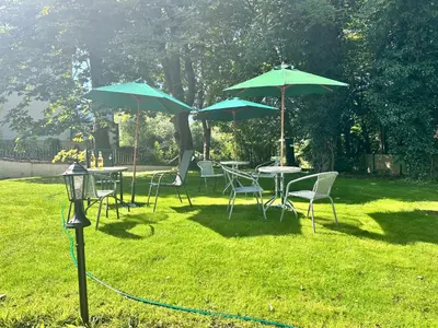 a group of tables and chairs with umbrellas at Fulwood House in Grimsargh