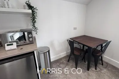 a small dining room table with chairs and a tv at New Sandpiper Apartments in Fleetwood