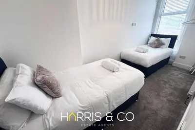 a bedroom with two beds and a couch at New Sandpiper Apartments in Fleetwood