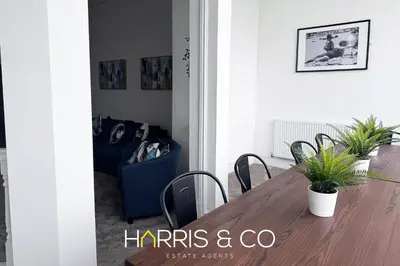 a dining room with a wooden table and chairs at New Sandpiper Apartments in Fleetwood
