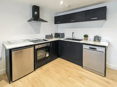 a kitchen with black cabinets and stainless steel appliances at No10 Apartments in Blackpool