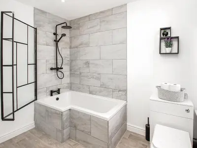 a white bathroom with a tub and a shower at No10 Apartments in Blackpool