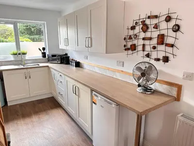 a kitchen with white cabinets and a fan on a counter at The Annexe, St Andrews house hotel, Two bedrooms Sleeps 4 in Preston
