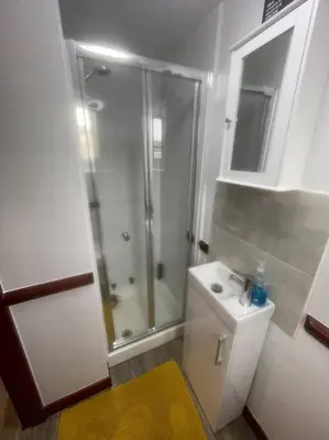 a white bathroom with a shower and a sink at Lovely flat in heart Blackpool in Blackpool