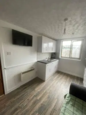 a kitchen with white cabinets and a sink in a room at Lovely flat in heart Blackpool in Blackpool