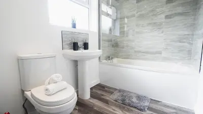 a bathroom with a toilet and a sink and a tub at Comfy Spacious Home Near Preston City Centre - Sleeps 6 in Samlesbury