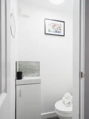 a white bathroom with a toilet and a sink at Comfy Spacious Home Near Preston City Centre - Sleeps 6 in Samlesbury