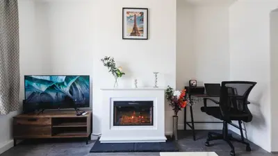 a living room with a fireplace and a television at Comfy Spacious Home Near Preston City Centre - Sleeps 6 in Samlesbury